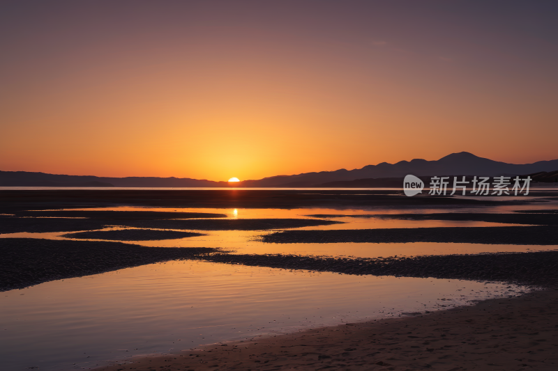 欣赏海滩上日落和水面的景色高清风景图片