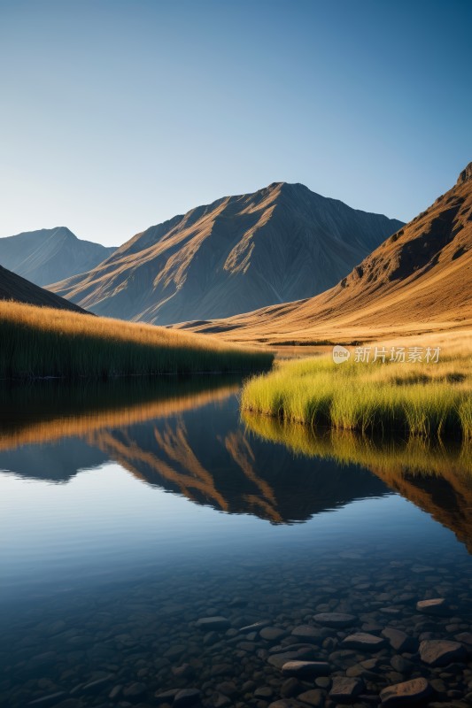 山倒映在湖中前景是草和岩石图片