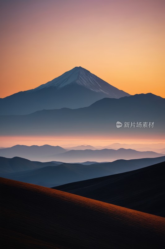 日落时分远处一座雪峰的山脉图片