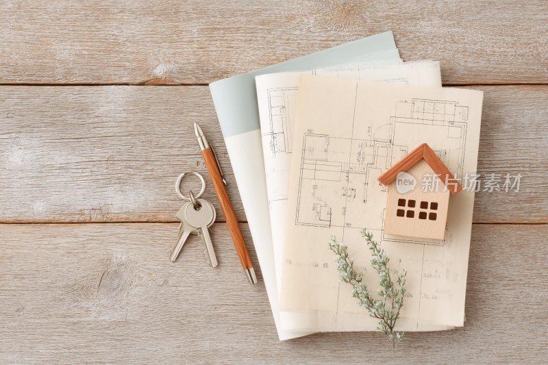 木质桌面的房屋图纸与装饰摆件