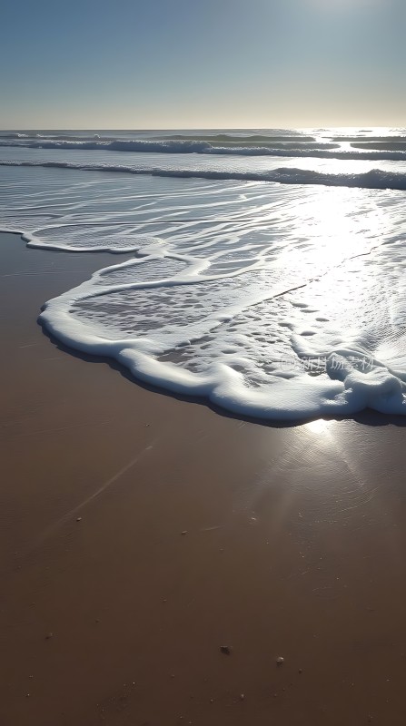 阳光下的海浪轻拍沙滩