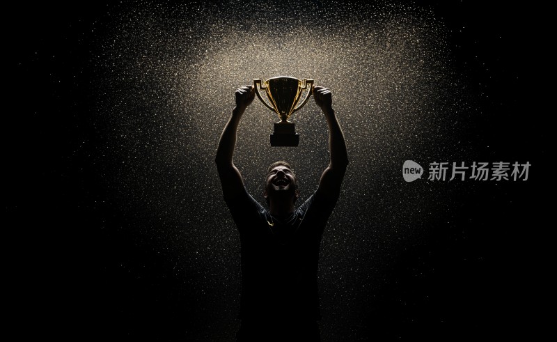 高举奖杯的胜利者剪影