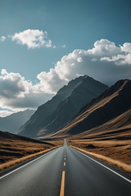 一条长长的道路穿过山脉天空图片