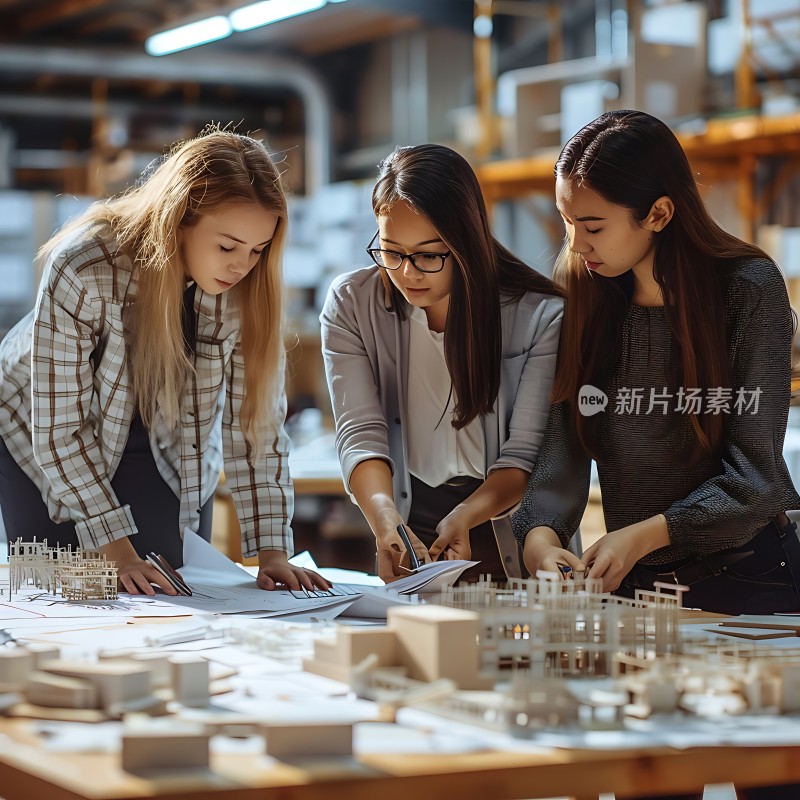 三位女性专注研究建筑图纸和模型