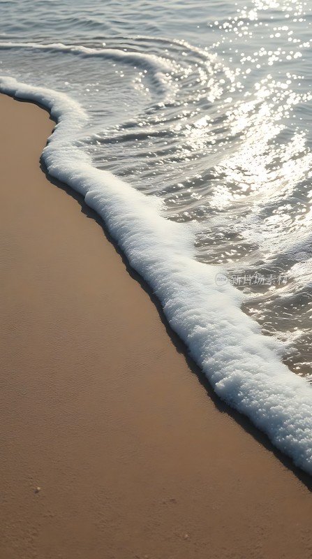阳光下的海浪轻拍沙滩