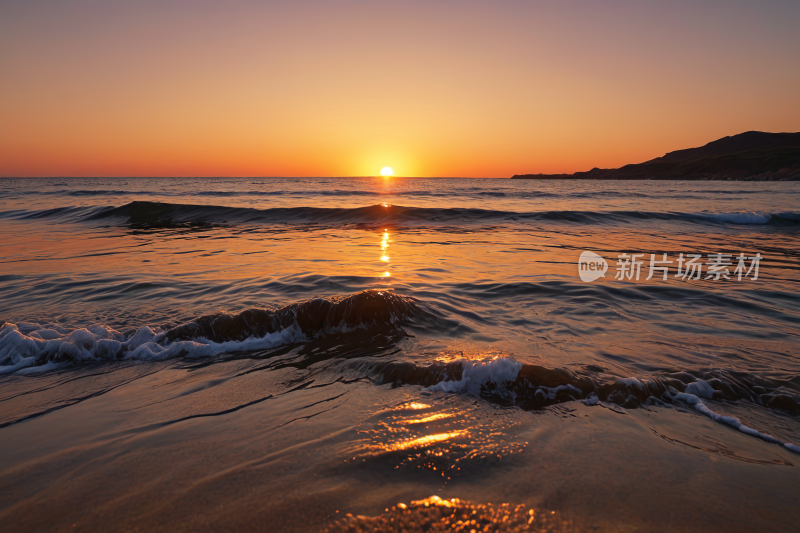 海洋上的日落伴随着海浪和小浪涌入风景图片