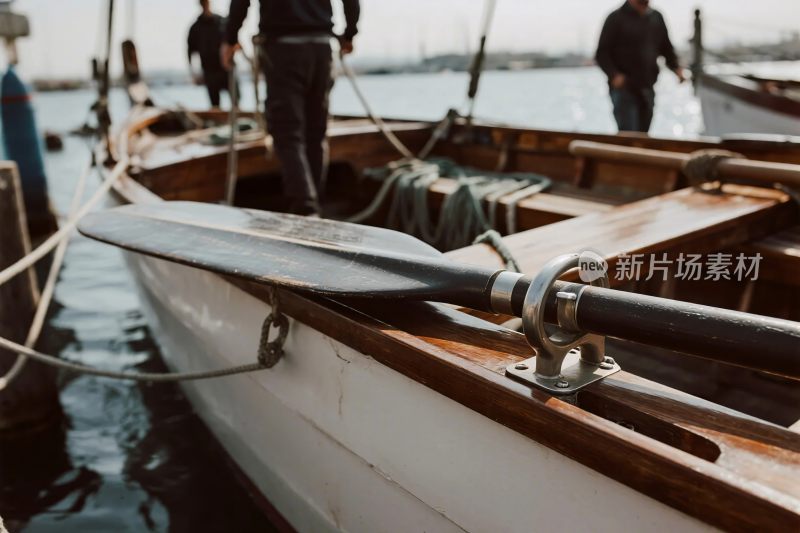 停靠岸边的木质小船及桨