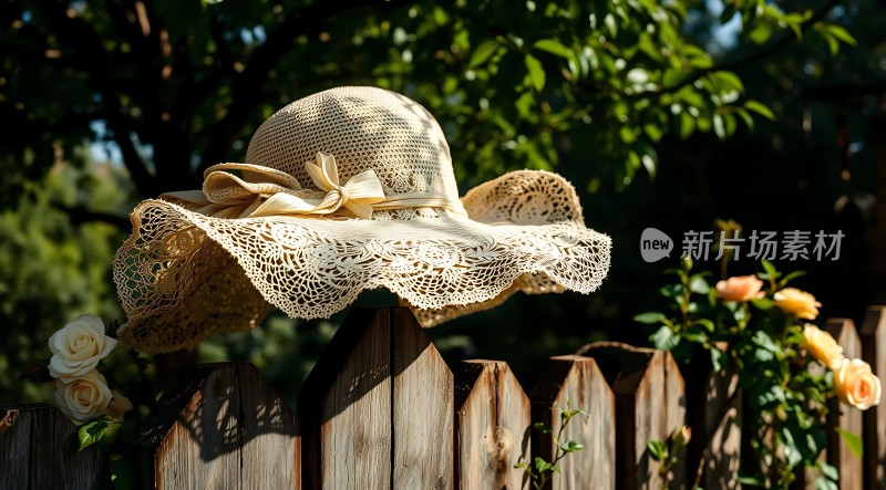 阳光下的蕾丝草帽与木栅栏