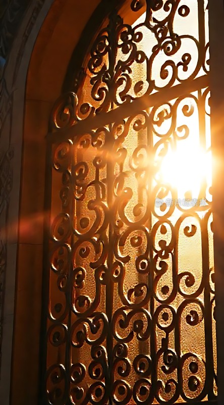 阳光透过铁艺窗棂洒下温暖光芒