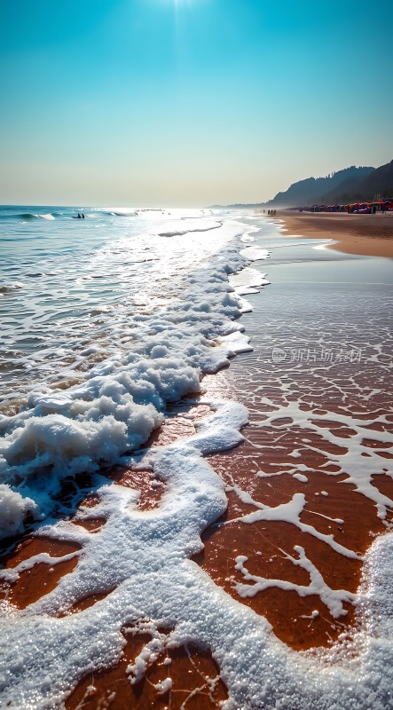 阳光下的海浪轻拍沙滩