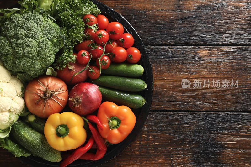 木桌上一盘新鲜多彩蔬菜