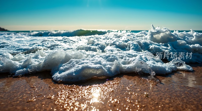 阳光下的海浪轻拍沙滩