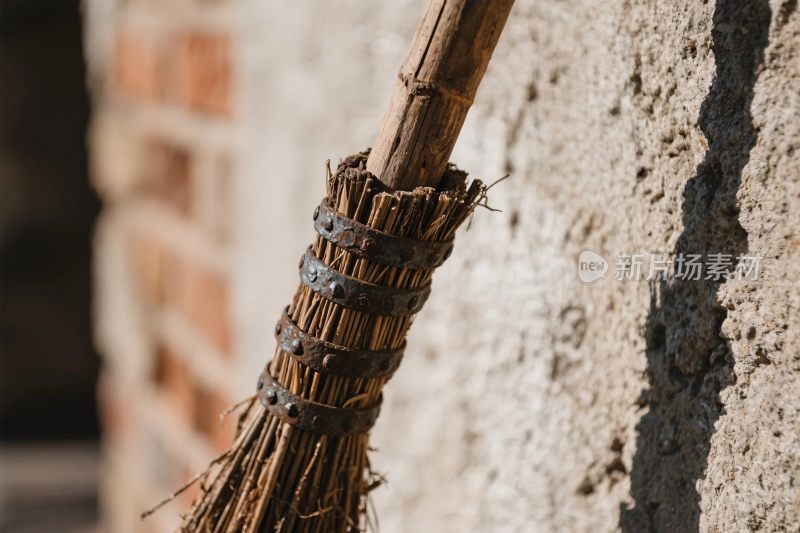 扫帚特写砖墙背景