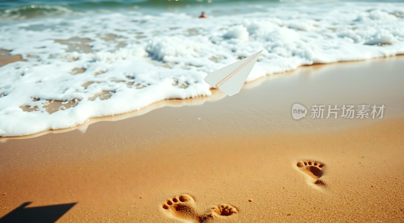 沙滩上的纸飞机与脚印