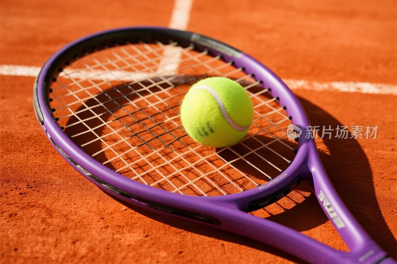 网球与网球拍在红土场地