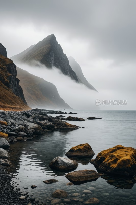 雾中湖岸上的山脉和岩石高清图片