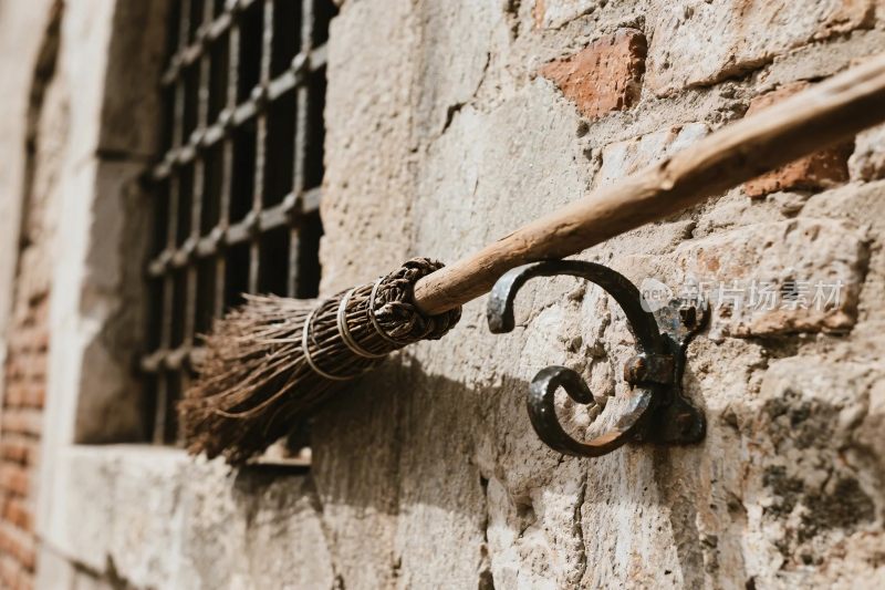 老墙上的扫帚与铁钩