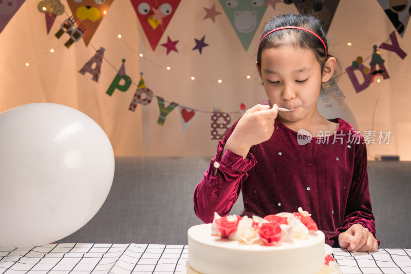 在生日会上吃生日蛋糕的中国女孩