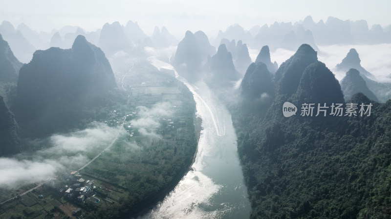 日出时桂林漓江峡谷中的云雾和水面上的竹筏