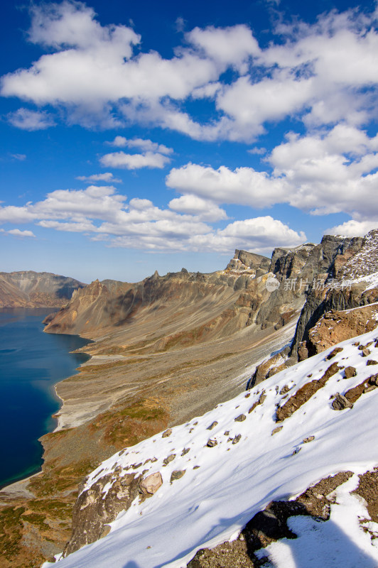 雪后蓝天白云下长白山天池南坡的侧面风景