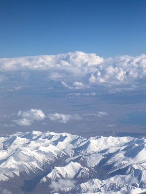 航拍视角下的新疆天山山脉雪山和蓝天白云