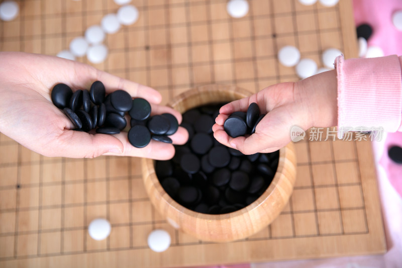 一只小手正把棋子放入棋盒中