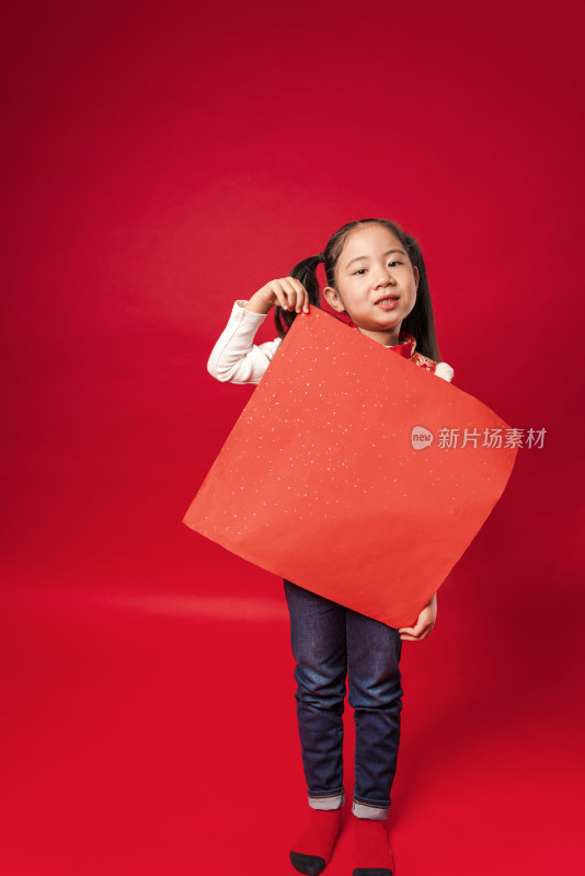 红色背景前穿唐装拿空白门贴纸的中国女孩