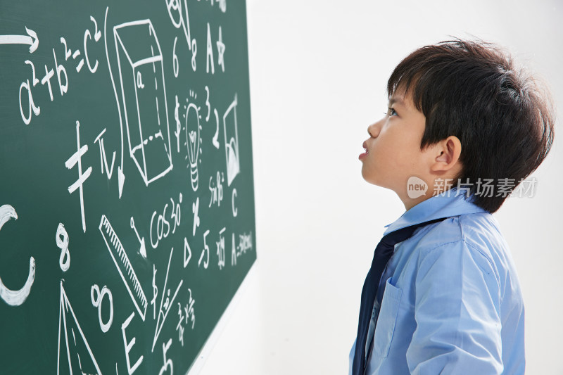 小学男生研究黑板上的数学题