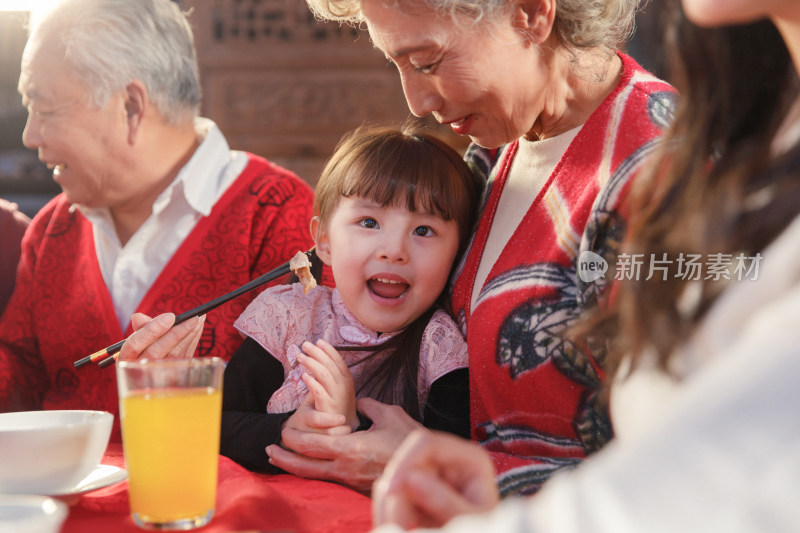 餐桌上祖母喂孙女吃饭