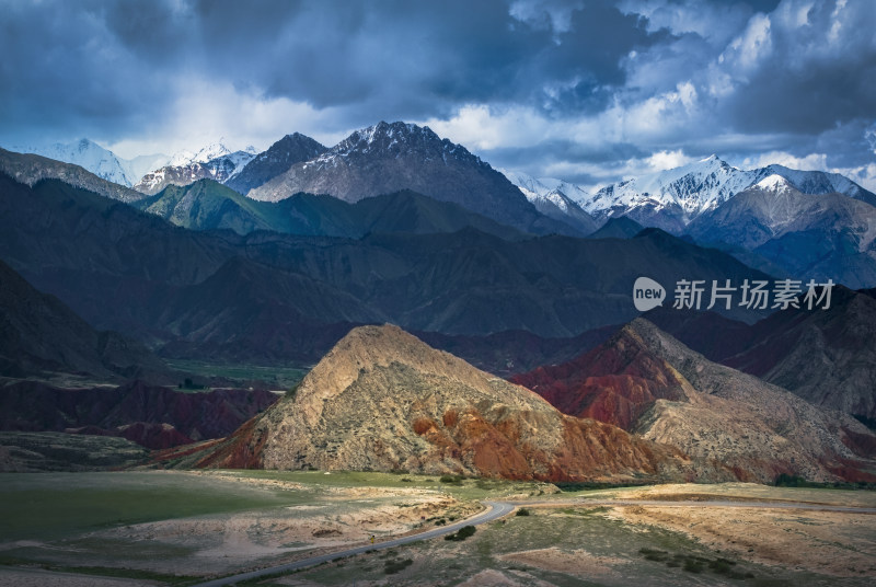 乌云下的雪山与多彩山峦风景