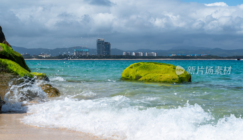 阳光下的海南三亚海岸线上礁石沙滩海浪浪花