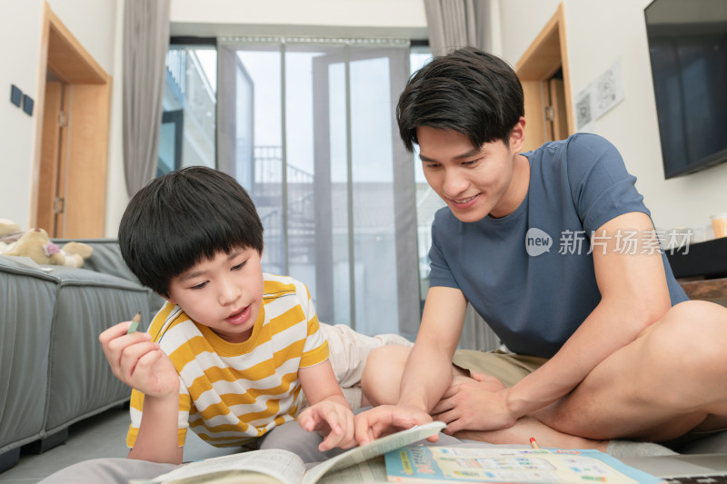 年轻爸爸辅导儿子做作业