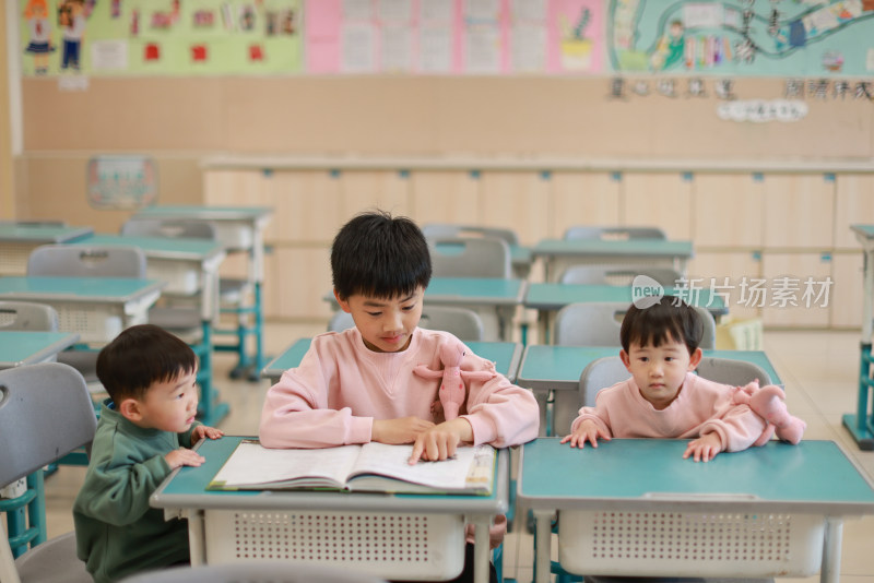 哥哥在教室里教弟弟妹妹看书