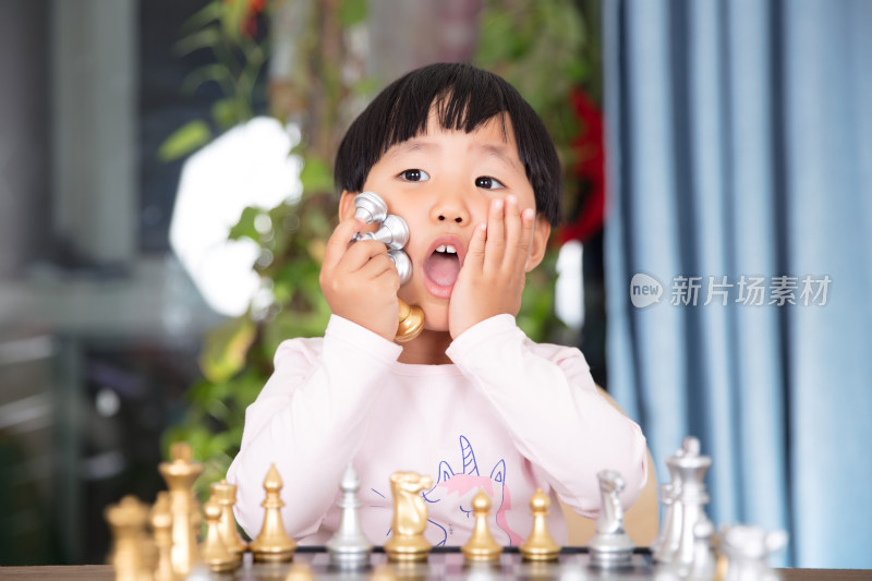 中国小姑娘手拿国际象棋棋子