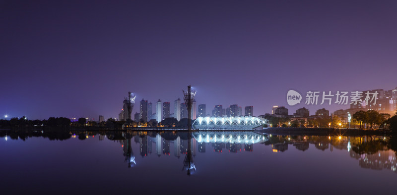 城市夜景中的高楼大厦倒映在平静湖面