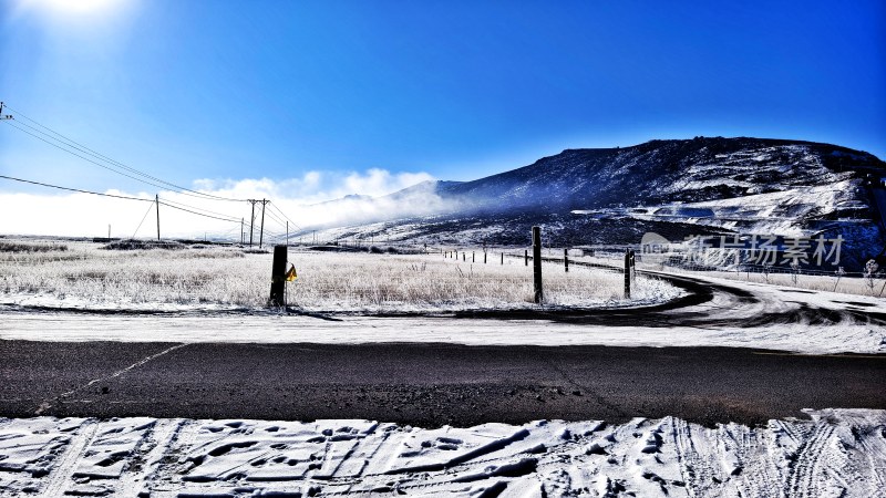 冰雪覆盖的弯曲山路与远方山峦全景