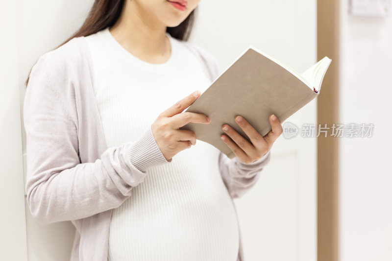 孕妇站着看书