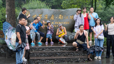 游客们冒雨游览成都都江堰景区