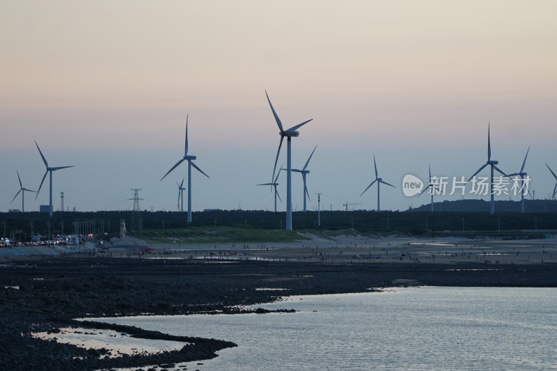 福建平潭镜沙日落下的风力发电