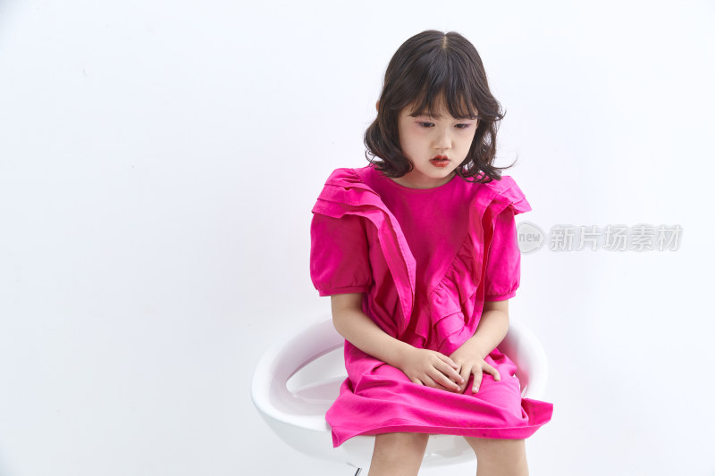 白色背景里坐在凳子上的可爱的亚洲小女孩（儿童）