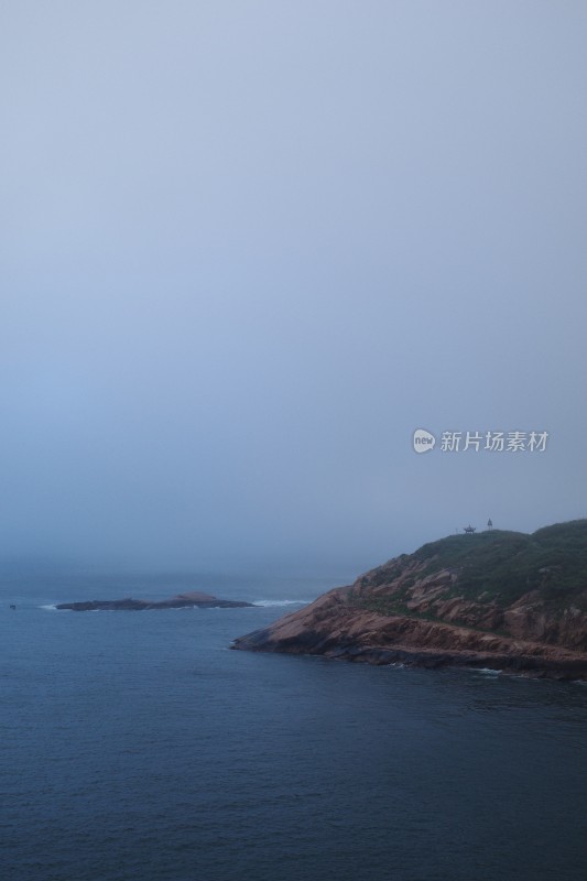 雾霭中海边礁石的宁静景象