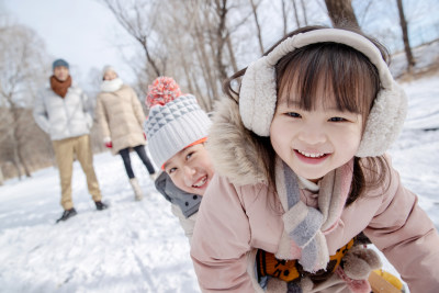 欢乐家庭在雪地上玩雪橇