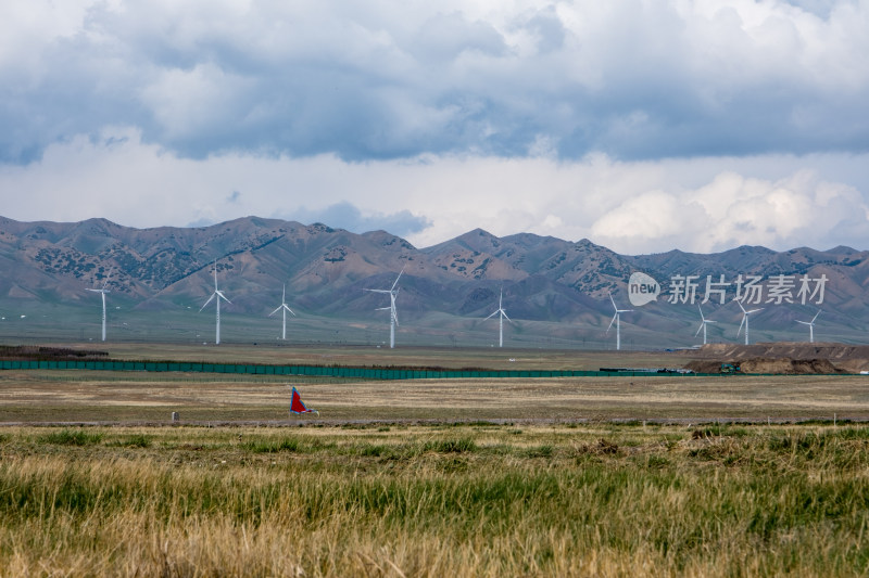 新疆草原雪山下的新能源风力发电机