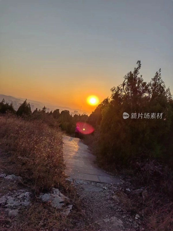 夕阳下有人行走的山间小路