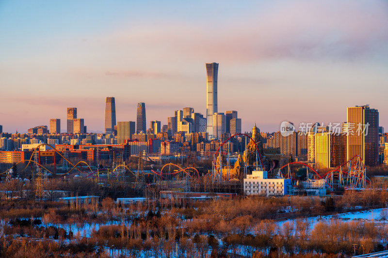 北京冬季雪后夕阳下的欢乐谷与中国尊同框