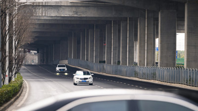 车辆行驶于高架桥下的公路上