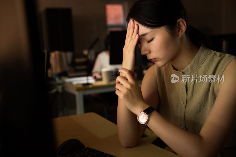 在办公室加班的年轻女士