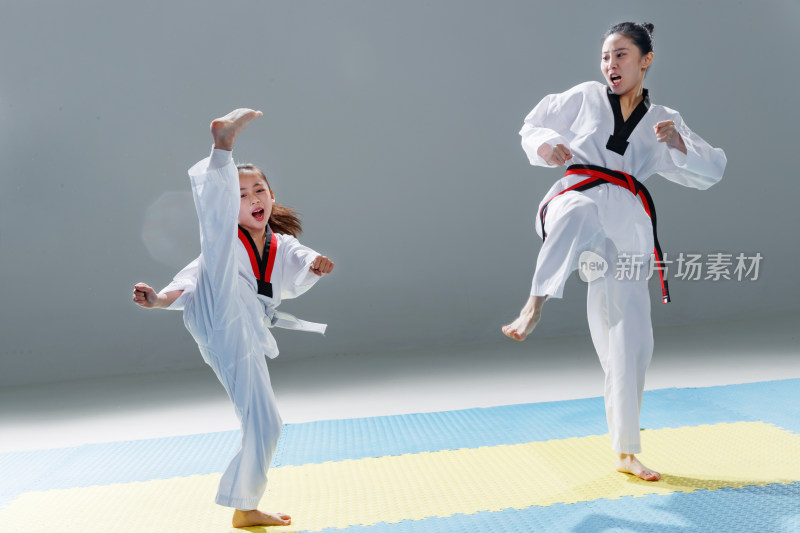 年轻教练教小女孩学跆拳道
