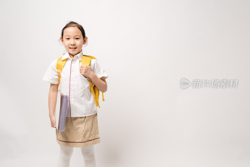 站在白色背景拿着作业本的中国女孩
