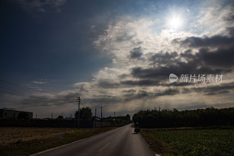 乡间道路上行驶的摩托车远景画面